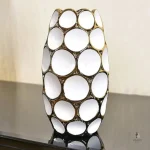 Vase chic blanc avec accents dorés, idéal pour fleurs