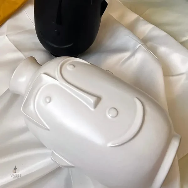 Vase en céramique blanche avec motif visage stylisé
