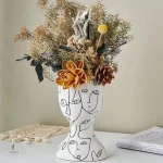 Vase décoratif avec motif de visage stylisé