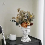 Vase en céramique avec illustration de visage