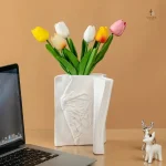 Vase original représentant un visage sur une couverture de livre