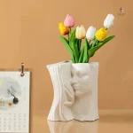 Élégant vase en forme de livre avec motif facial