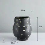 Vase noir stylé avec détails dorés, parfait pour un centre de table