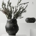 Vase décoratif noir orné de motifs dorés