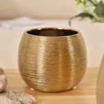 Vase doré arrondi, pièce maîtresse pour la table